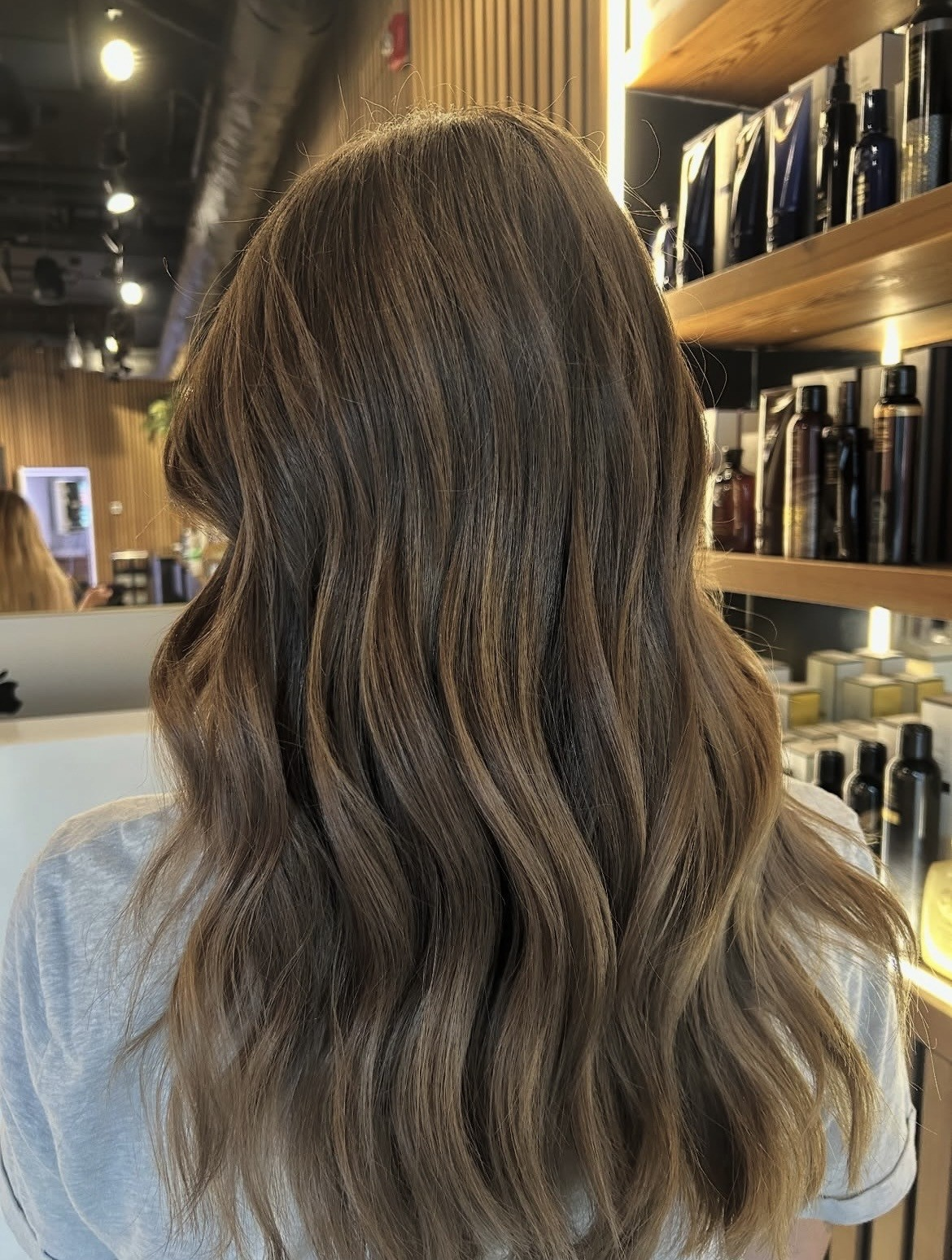 Long wavy brunette hair with soft sun-kissed balayage, viewed from behind